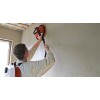 Façadier utilisant la machine de finition IMER PFM WT pour lisser un enduit monocouche sur échafaudage