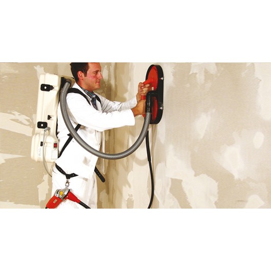 Façadier portant l'aspirateur dorsal IMER RVC-L pendant le ponçage d'un panneau ITE sur échafaudage