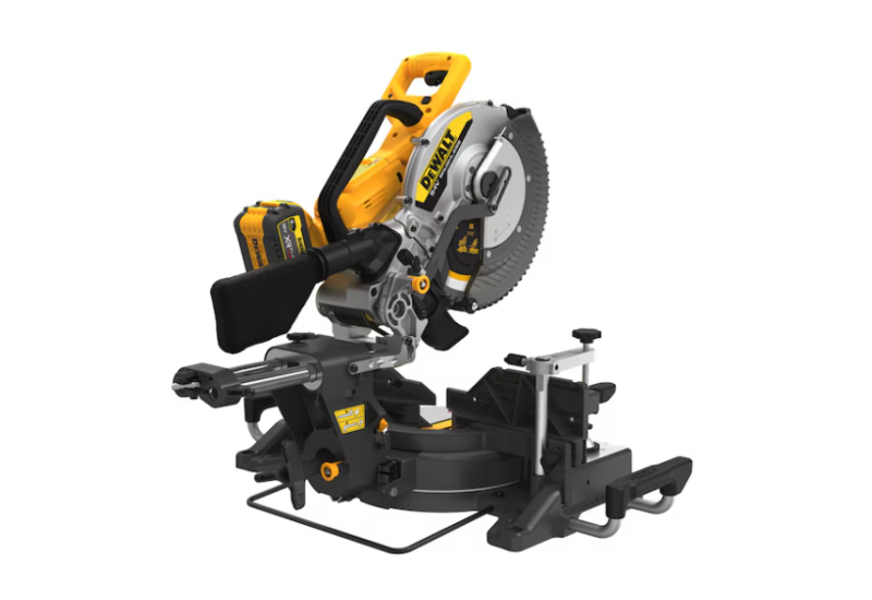 Scie à onglets sans fil 54V DEWALT transportée sur un chantier. Scie à onglets sans fil 54V DEWALT transportée sur un chantier.