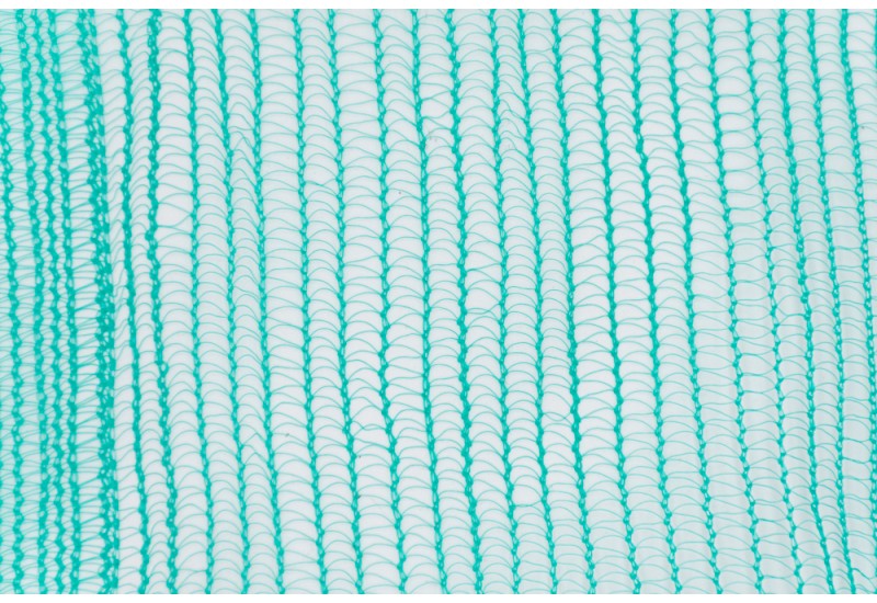 Rouleau de filet pare-gravats vert 50g installé sur structure d'échafaudage métallique.