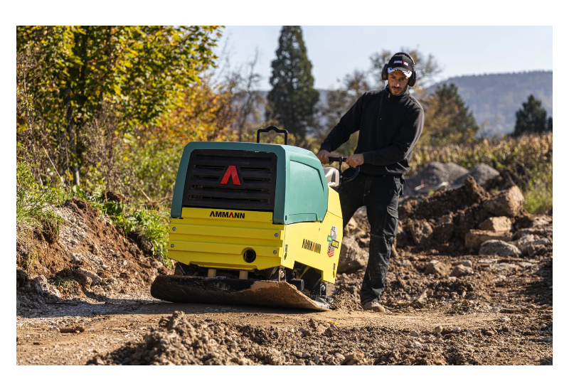 Compacteur de sol bidirectionnel Ammann APH 85/95 en action sur chantier de terrassement.