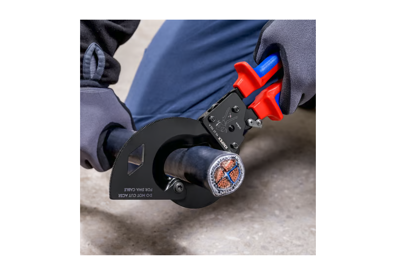 Utilisation à une main du coupe-câbles compact KNIPEX 95 32 315 A en espace restreint.