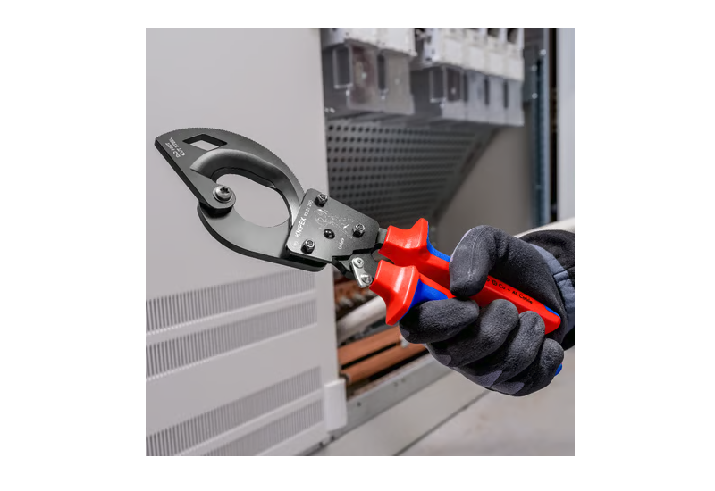 Utilisation à une main du coupe-câbles à cliquet Knipex sur câble cuivre.