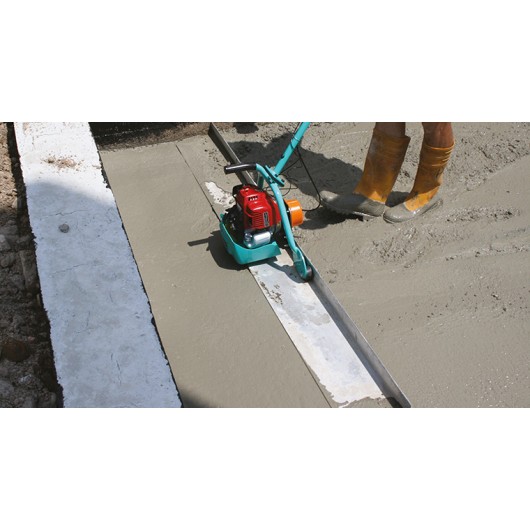 Opérateur utilisant la règle vibrante IMER pour un surfaçage précis de dalle béton Opérateur utilisant la règle vibrante IMER pour un surfaçage précis de dalle béton